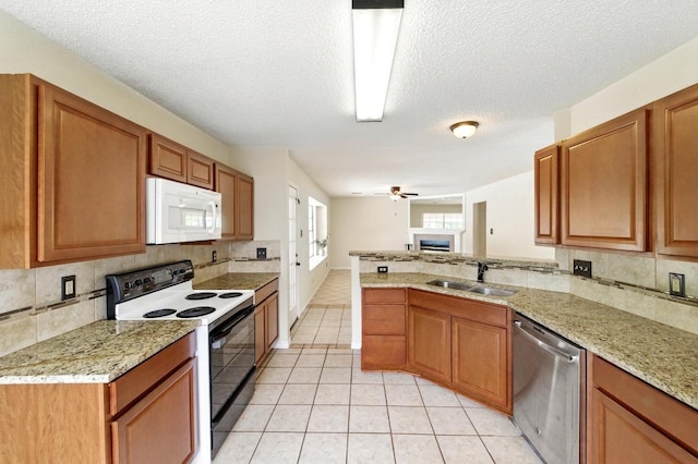 kitchen featuring range with electric stovetop, white microwave, dishwasher, a sink, and tasteful backsplash