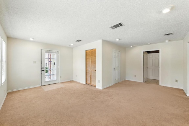 spare room with light colored carpet, baseboards, a textured ceiling, and recessed lighting
