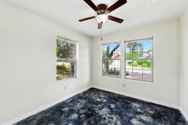 empty room with plenty of natural light, baseboards, carpet, a ceiling fan, and a textured ceiling