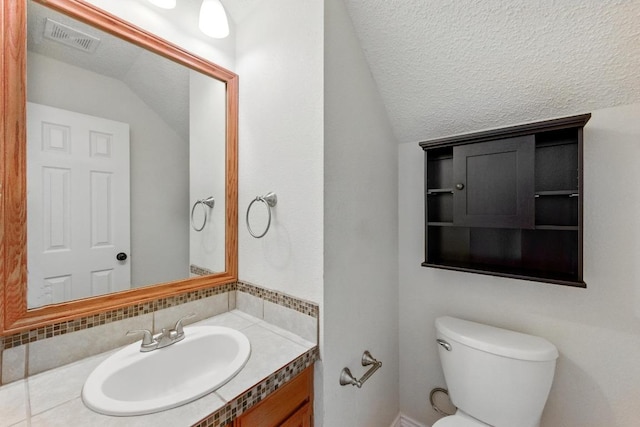 half bathroom featuring vaulted ceiling, toilet, and vanity