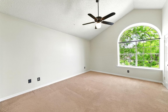 spare room featuring vaulted ceiling, a ceiling fan, carpet flooring, baseboards, and a textured ceiling