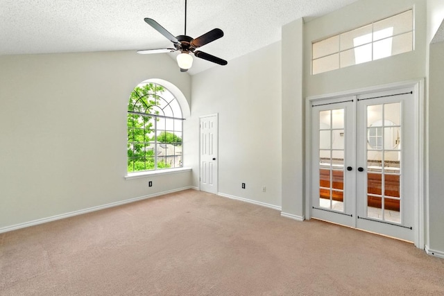carpeted empty room with french doors, high vaulted ceiling, a ceiling fan, baseboards, and a textured ceiling