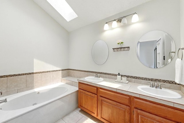 full bath with a skylight, lofted ceiling, a tub with jets, double vanity, and tile patterned floors