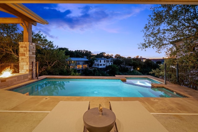 1107 Challenger, Lakeway, TX 78734 - view of pool featuring a patio area, a lit fireplace, and a pool with connected hot tub