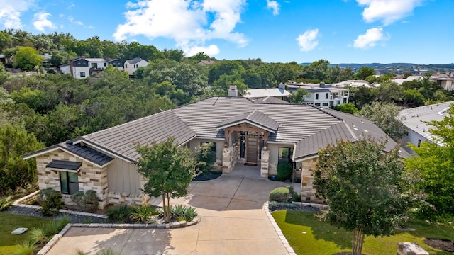 1107 Challenger, Lakeway, TX 78734 - view of front of property featuring stone siding, a chimney, and a tile roof