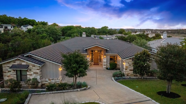 1107 Challenger, Lakeway, TX 78734 - view of front of property with stone siding, driveway, a tile roof, a chimney, and board and batten siding