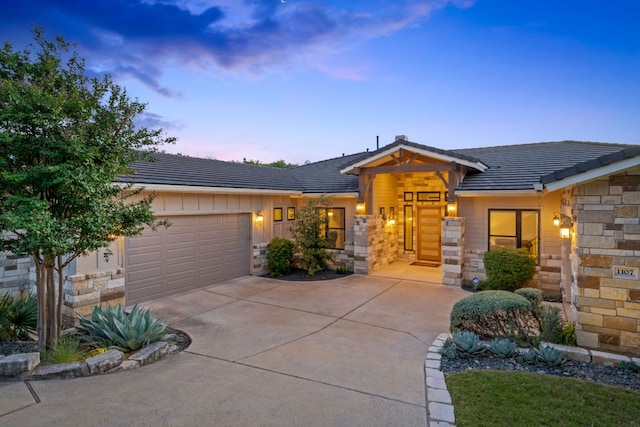 1107 Challenger, Lakeway, TX 78734 - view of front of house with stone siding, an attached garage, driveway, and board and batten siding