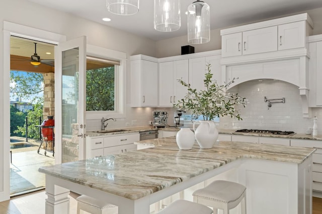1107 Challenger, Lakeway, TX 78734 - kitchen with gas stovetop, tasteful backsplash, a ceiling fan, a kitchen island, and white cabinets