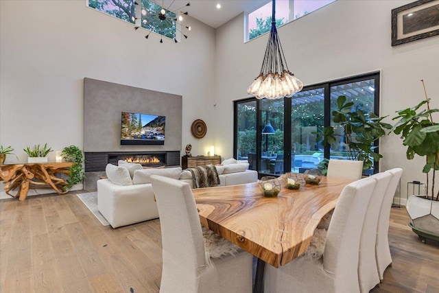 2010 Goodrich Ave Unit 5A, Austin, TX 78704 - dining room featuring a high ceiling, a chandelier, wood finished floors, and healthy amount of natural light