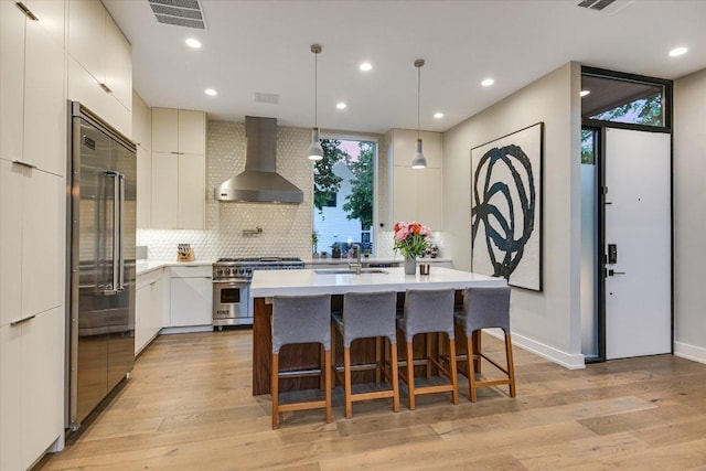 2010 Goodrich Ave Unit 5A, Austin, TX 78704 - kitchen with high end appliances, wall chimney exhaust hood, a sink, tasteful backsplash, and light countertops