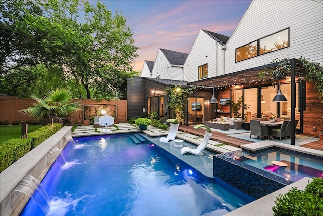 2010 Goodrich Ave Unit 5A, Austin, TX 78704 - pool at dusk with an outdoor hangout area, a fenced backyard, and a pool with connected hot tub