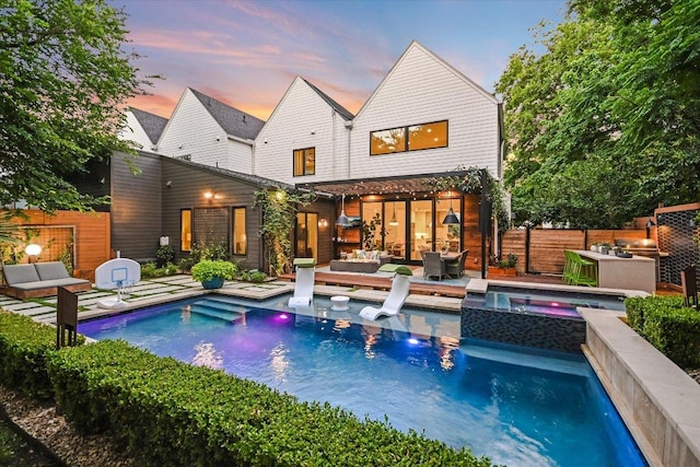 2010 Goodrich Ave Unit 5A, Austin, TX 78704 - back of house at dusk featuring an outdoor living space and a pool with connected hot tub