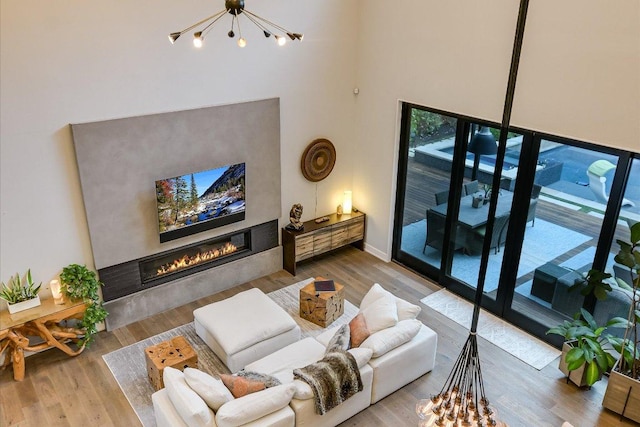 2010 Goodrich Ave Unit 5A, Austin, TX 78704 - living room with a chandelier, a glass covered fireplace, a towering ceiling, and wood finished floors