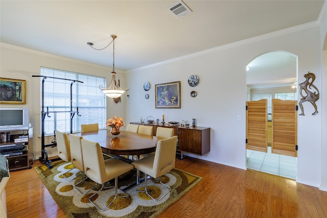5219 Moon Shadow Dr, Austin, TX 78735 - dining room featuring arched walkways, wood finished floors, ornamental molding, and baseboards
