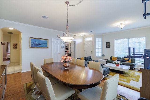 5219 Moon Shadow Dr, Austin, TX 78735 - dining area featuring arched walkways, ornamental molding, wood finished floors, and baseboards