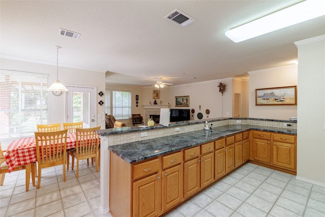 5219 Moon Shadow Dr, Austin, TX 78735 - kitchen featuring ornamental molding, pendant lighting, a peninsula, light tile patterned floors, and ceiling fan