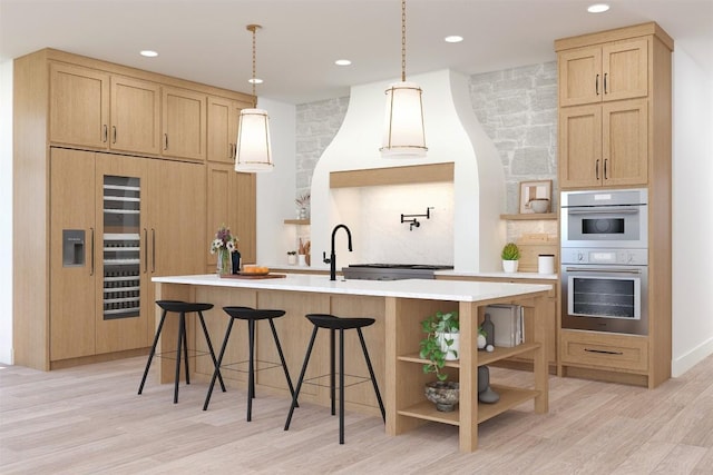 kitchen with open shelves, light countertops, white double oven, light wood-style flooring, and a center island with sink