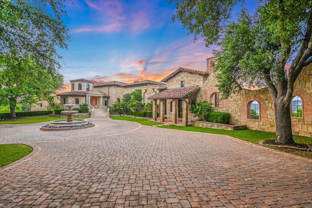 12861 Hughes Park Rd, Austin, TX 78732 - mediterranean / spanish-style house with stone siding and curved driveway