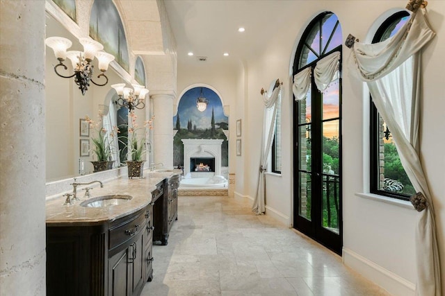 12861 Hughes Park Rd, Austin, TX 78732 - bathroom featuring vanity, a garden tub, recessed lighting, a lit fireplace, and baseboards