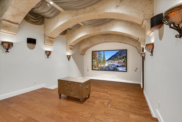 12861 Hughes Park Rd, Austin, TX 78732 - home theater with wood finished floors, baseboards, and arched walkways