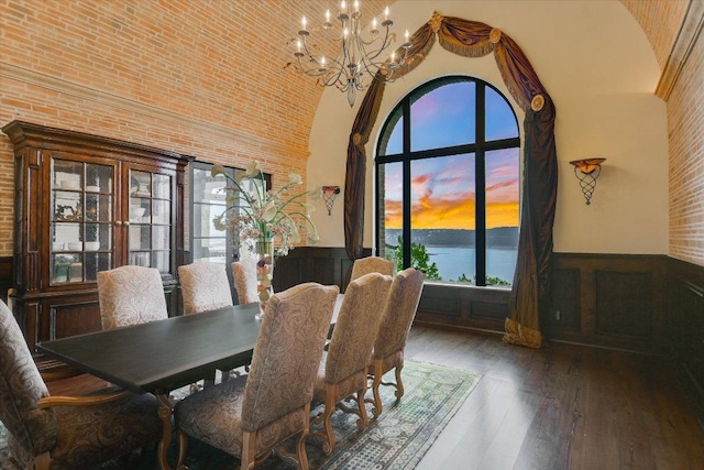 12861 Hughes Park Rd, Austin, TX 78732 - dining room featuring a high ceiling, a chandelier, a wainscoted wall, a water view, and wood finished floors