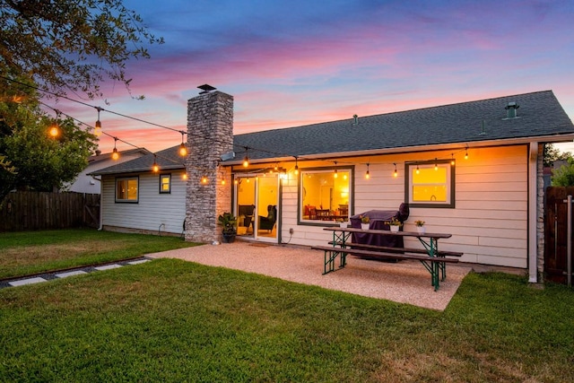 8907 Hunters Trce, Austin, TX 78758 - back of property at dusk featuring a chimney, a patio, and roof with shingles