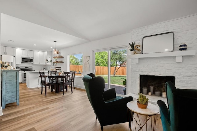 8907 Hunters Trce, Austin, TX 78758 - living area featuring vaulted ceiling, light wood-style floors, a fireplace, and recessed lighting