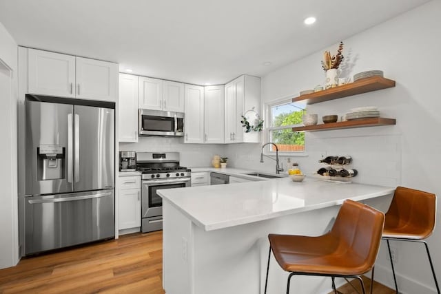 8907 Hunters Trce, Austin, TX 78758 - kitchen with stainless steel appliances, a sink, a peninsula, decorative backsplash, and white cabinetry