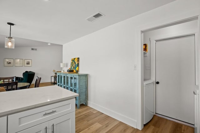 8907 Hunters Trce, Austin, TX 78758 - kitchen featuring light wood-style floors, white cabinets, recessed lighting, and hanging light fixtures
