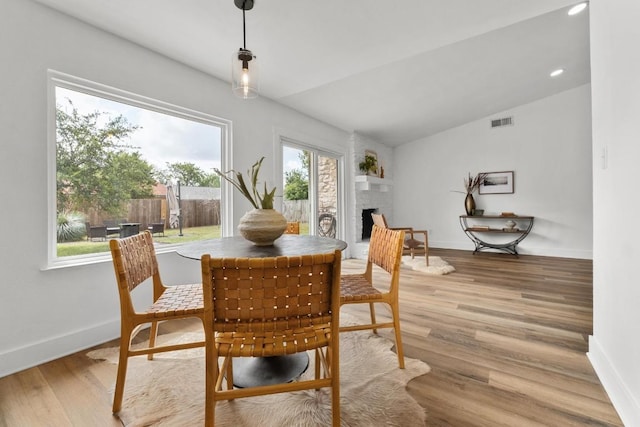 8907 Hunters Trce, Austin, TX 78758 - dining area with lofted ceiling, a fireplace, light wood finished floors, and recessed lighting