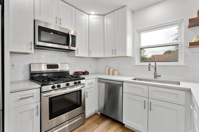 8907 Hunters Trce, Austin, TX 78758 - kitchen featuring appliances with stainless steel finishes, white cabinetry, light countertops, and backsplash