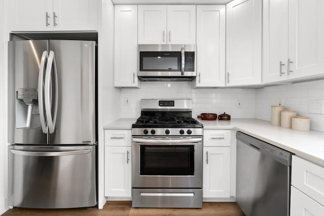 8907 Hunters Trce, Austin, TX 78758 - kitchen featuring appliances with stainless steel finishes, white cabinets, light countertops, and backsplash