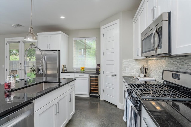 705 E 49th St Unit A, Austin, TX 78751 - kitchen with stainless steel appliances, beverage cooler, tasteful backsplash, decorative light fixtures, and white cabinets