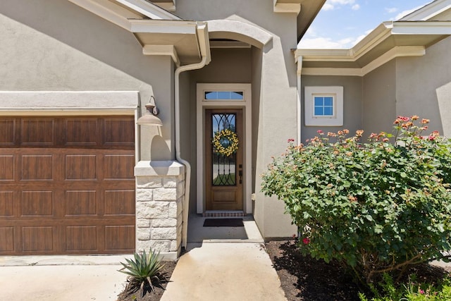 138 Prism Cv, Dripping Springs, TX 78620 - view of exterior entry with stucco siding and an attached garage