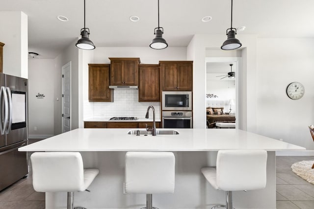 138 Prism Cv, Dripping Springs, TX 78620 - kitchen with appliances with stainless steel finishes, a sink, light tile patterned floors, tasteful backsplash, and a ceiling fan
