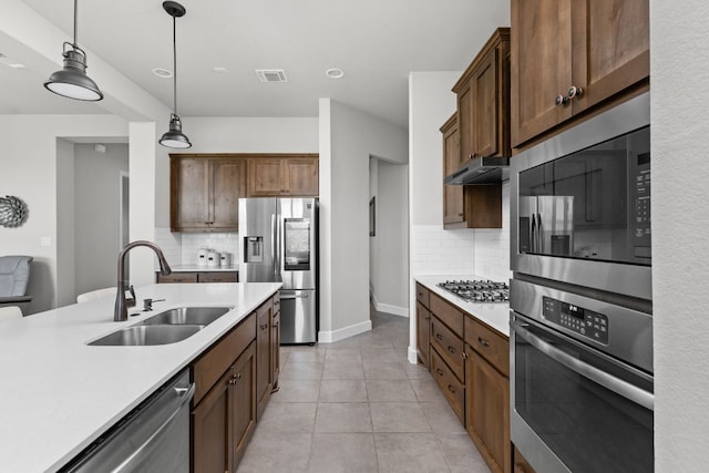 138 Prism Cv, Dripping Springs, TX 78620 - kitchen featuring stainless steel appliances, a sink, light countertops, and tasteful backsplash