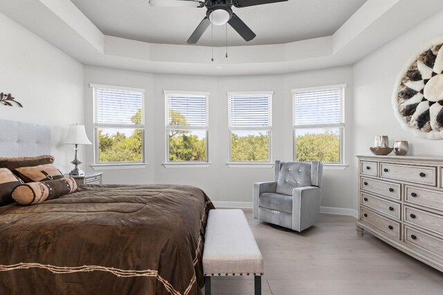 138 Prism Cv, Dripping Springs, TX 78620 - bedroom with multiple windows, baseboards, light wood-style floors, and ceiling fan