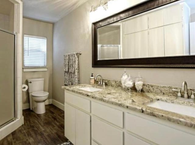 109 Ridgeview, Horseshoe Bay, TX 78657 - full bath featuring a stall shower, toilet, double vanity, and baseboards