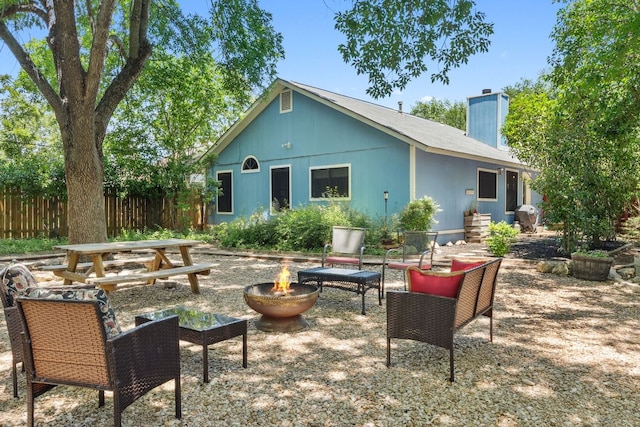 10730 N Platt River Dr, Austin, TX 78748 - back of property with a chimney, fence, an outdoor living space with a fire pit, and a patio