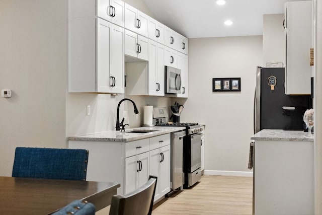 10730 N Platt River Dr, Austin, TX 78748 - kitchen featuring stainless steel appliances, a sink, baseboards, light wood-style flooring, and recessed lighting