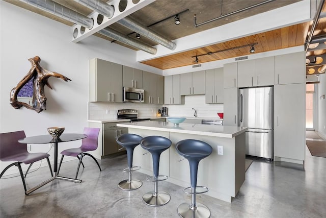 1401 Eva St Unit 406, Austin, TX 78704 - kitchen featuring stainless steel appliances, concrete floors, gray cabinets, and decorative backsplash