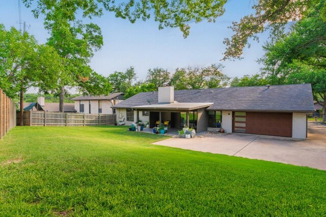 9421 Spring Hollow Dr, Austin, TX 78750 - rear view of house with a garage, a chimney, concrete driveway, and brick siding