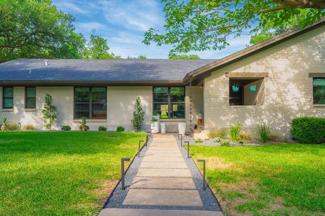 9421 Spring Hollow Dr, Austin, TX 78750 - view of front of house with brick siding, a front lawn, and roof with shingles