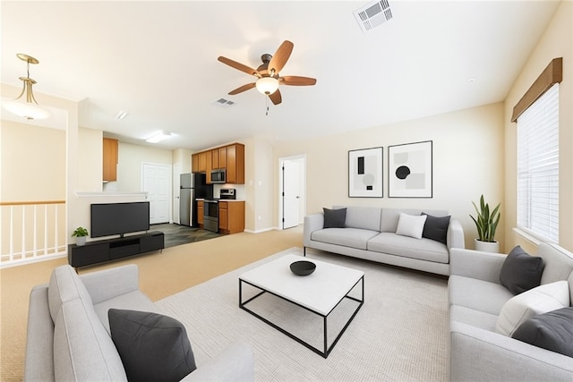 living room with dark colored carpet, a ceiling fan, and baseboards