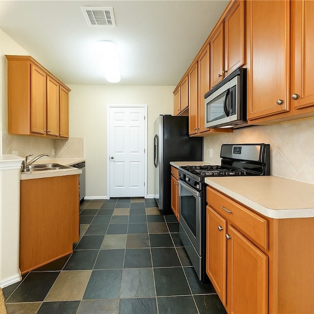 kitchen with appliances with stainless steel finishes, a sink, decorative backsplash, baseboards, and light countertops
