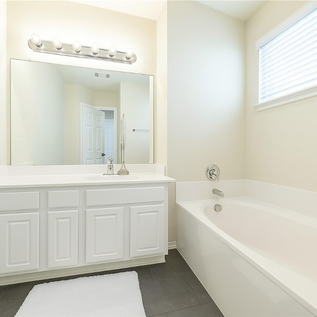 bathroom with tile patterned floors, a bath, and vanity