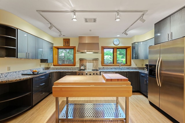2507 Inwood Pl, Austin, TX 78703 - kitchen with stainless steel fridge, wall chimney exhaust hood, track lighting, and open shelves