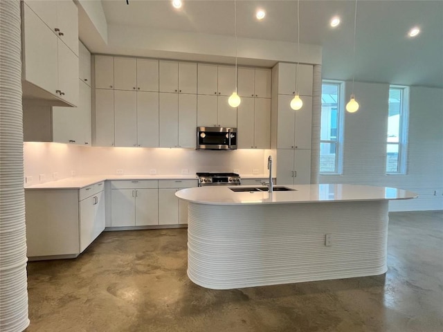 221 Blue Blaze Trl, Georgetown, TX 78628 - kitchen featuring appliances with stainless steel finishes, concrete flooring, a sink, light countertops, and a kitchen island with sink