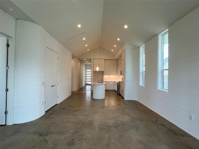 221 Blue Blaze Trl, Georgetown, TX 78628 - unfurnished living room featuring finished concrete flooring, vaulted ceiling, a sink, and recessed lighting