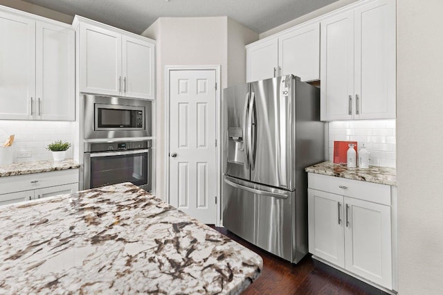 433 Vista Portola Loop, Liberty Hill, TX 78642 - kitchen with stainless steel appliances, white cabinets, light stone counters, and dark wood finished floors